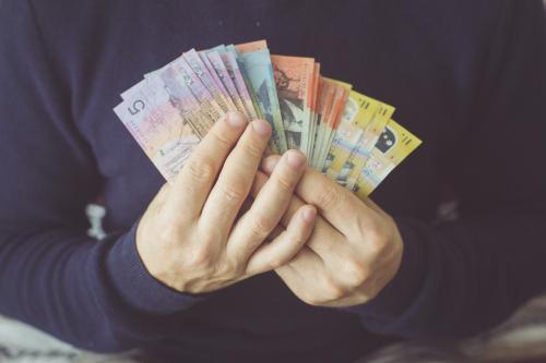 man holding money in Australian dollars cash