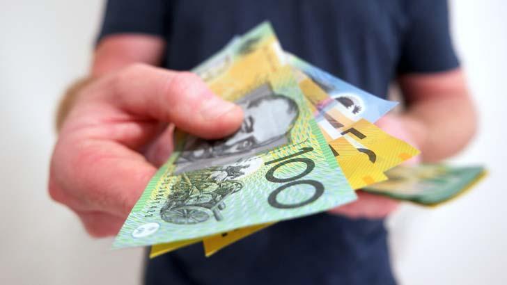 man handing money over to someone to pay in Australian dollars cash